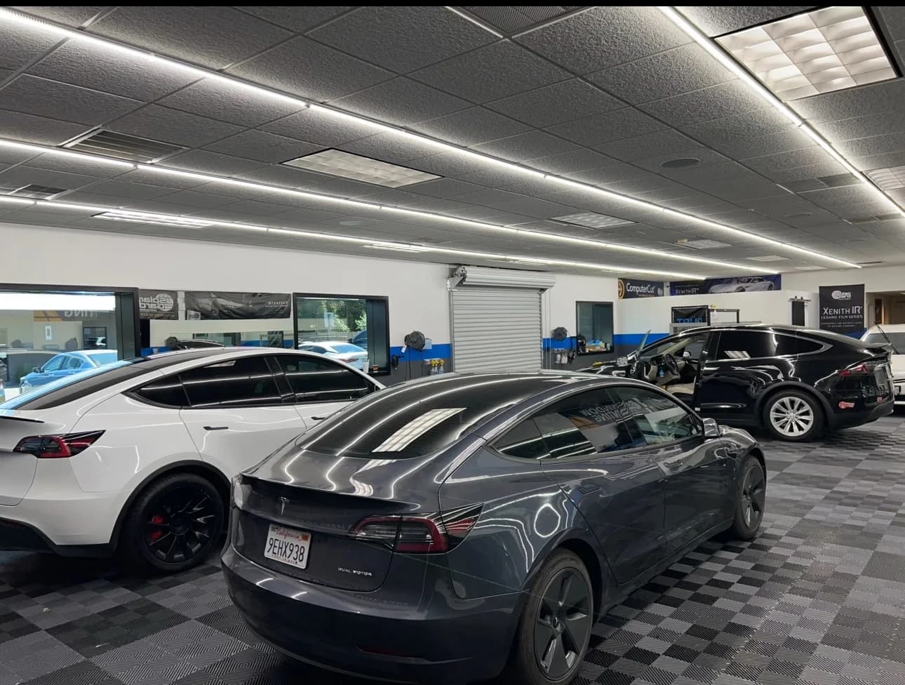Professional automotive shop interior at Modesto Window Tint showing luxury vehicles
