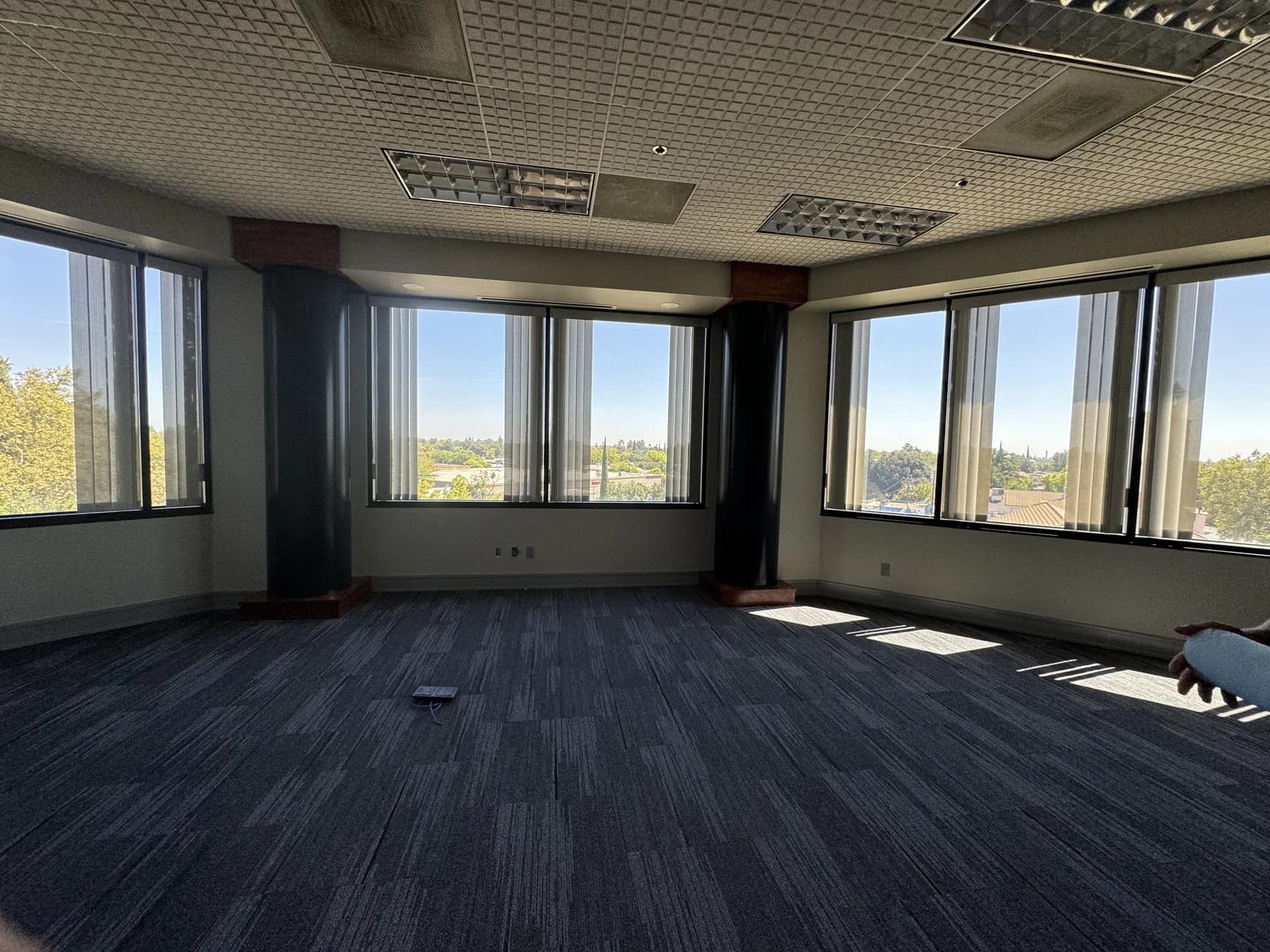 Open-plan office floor with a full wall of windows treated with solar control film