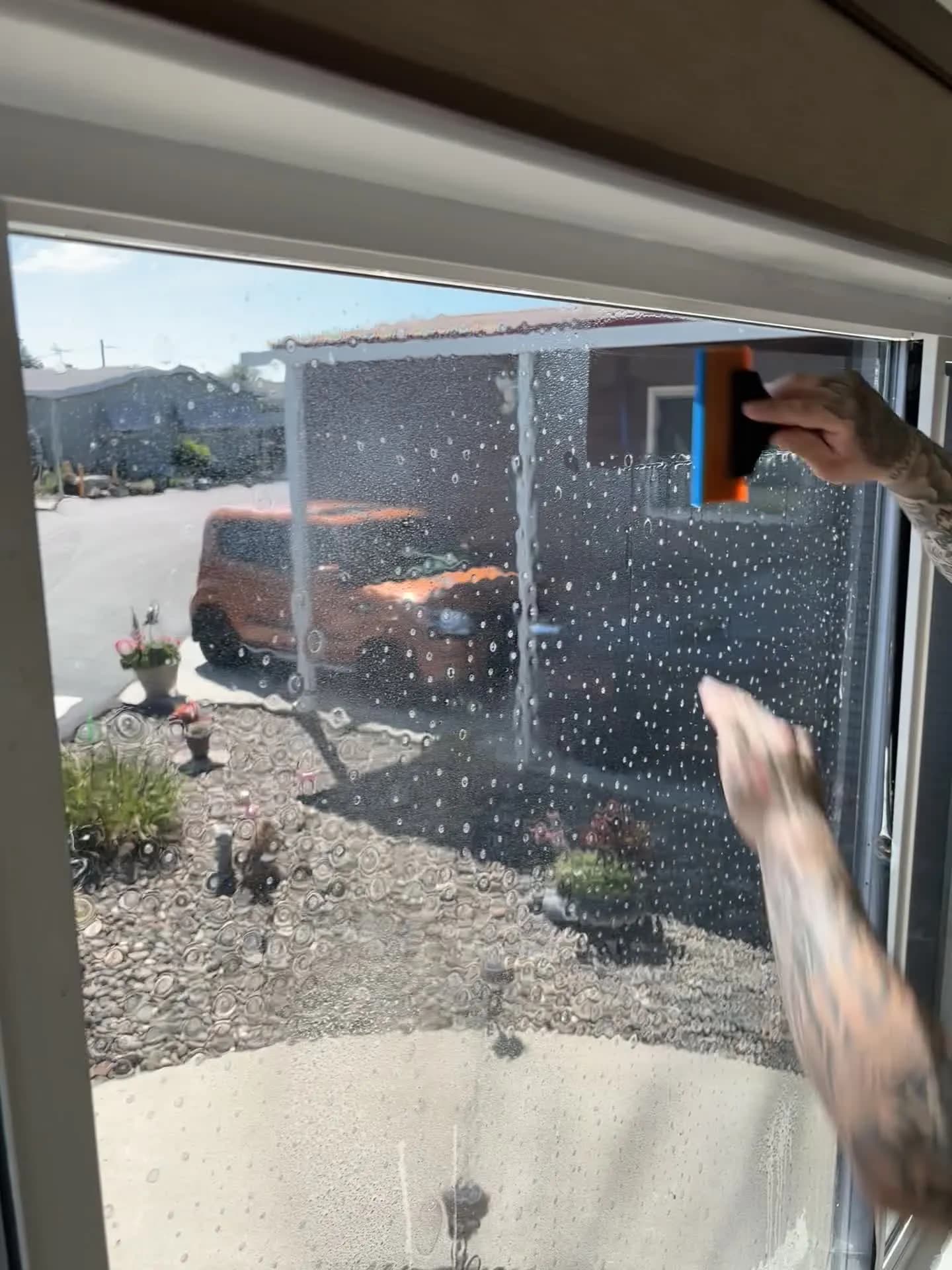 Installer fitting window film to a mobile home in Modesto