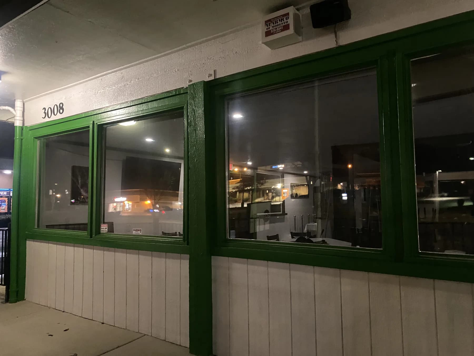 Tinted restaurant storefront windows in Modesto photographed in the evening