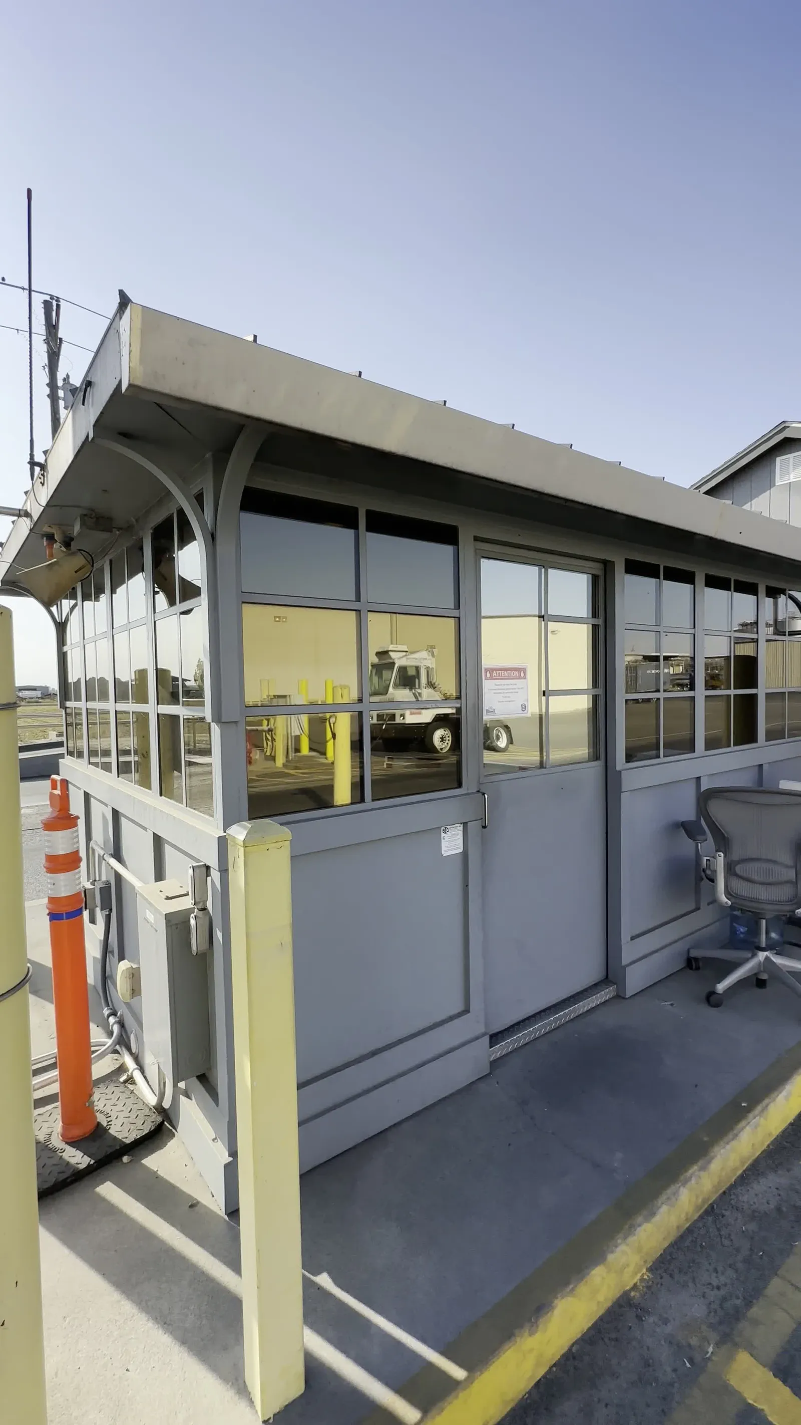Wraparound glazing on a security checkpoint booth treated with window film