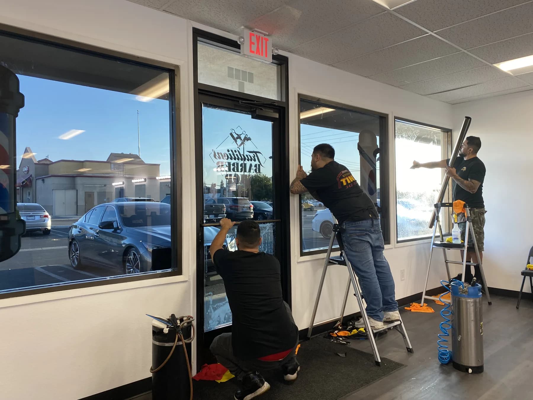 Crew installing window tint at Traditions Barbershop in Modesto