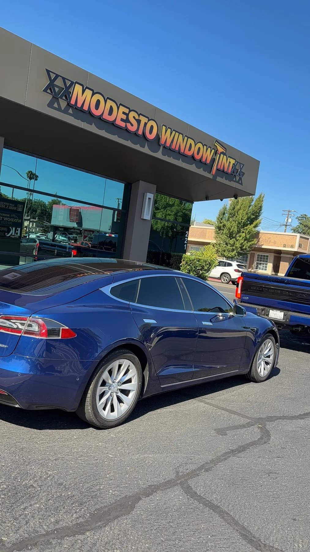 Blue Tesla Model S with professional window tinting at the Modesto Window Tint shop